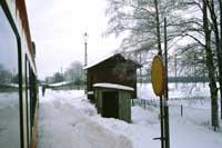Gräveby hållplatskur, godsmagasin och påstigningstavla den 16 februari 1985. - klicka för att förstora