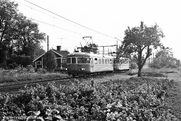 Två elmotorvagnar av littera X16 eller X17 passerar Lindbacka banvaktstuga på väg mot Örebro C vid mitten av 1980-talet. - klicka för att stänga rutan