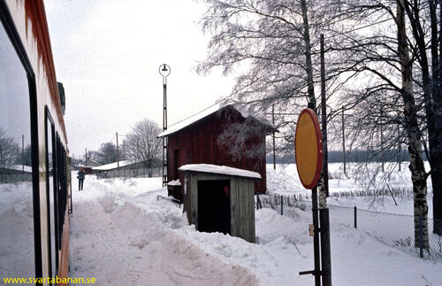 Gräveby hållplatskur, godsmagasin och påstigningstavla den 16 februari 1985. - klicka för att förstora
