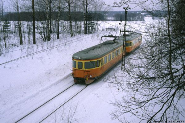 Elmotorvagnar passerar under bron vid Östertysslinge hållplats den 16 februari 1985. - klicka för att stänga rutan