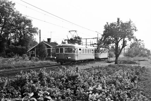 Två elmotorvagnar av littera X16 eller X17 passerar Lindbacka banvaktstuga på väg mot Örebro C vid mitten av 1980-talet. - klicka för att förstora