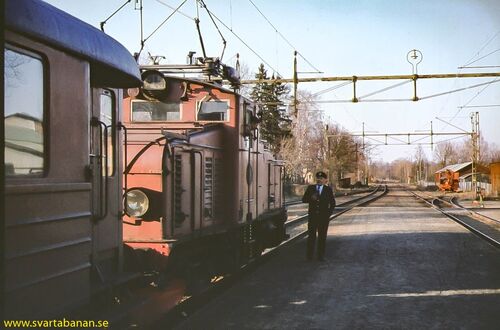Järnvägspersonal i samspråk på plattformen i Fjugesta i maj 1978. - klicka för att förstora
