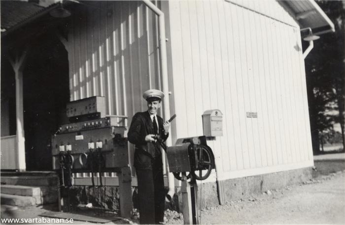 Stationskarl Helge Eklund fäller vägbommar med vevarna vid stationshuset i Mullhyttemo. - klicka för att stänga rutan