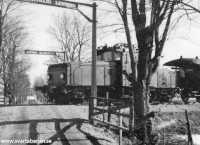 Ett elloksdraget tåg vid korsningen mellan Svartåbanan och Södra Holmstorp någon gång i mars 1956. - klicka för att förstora